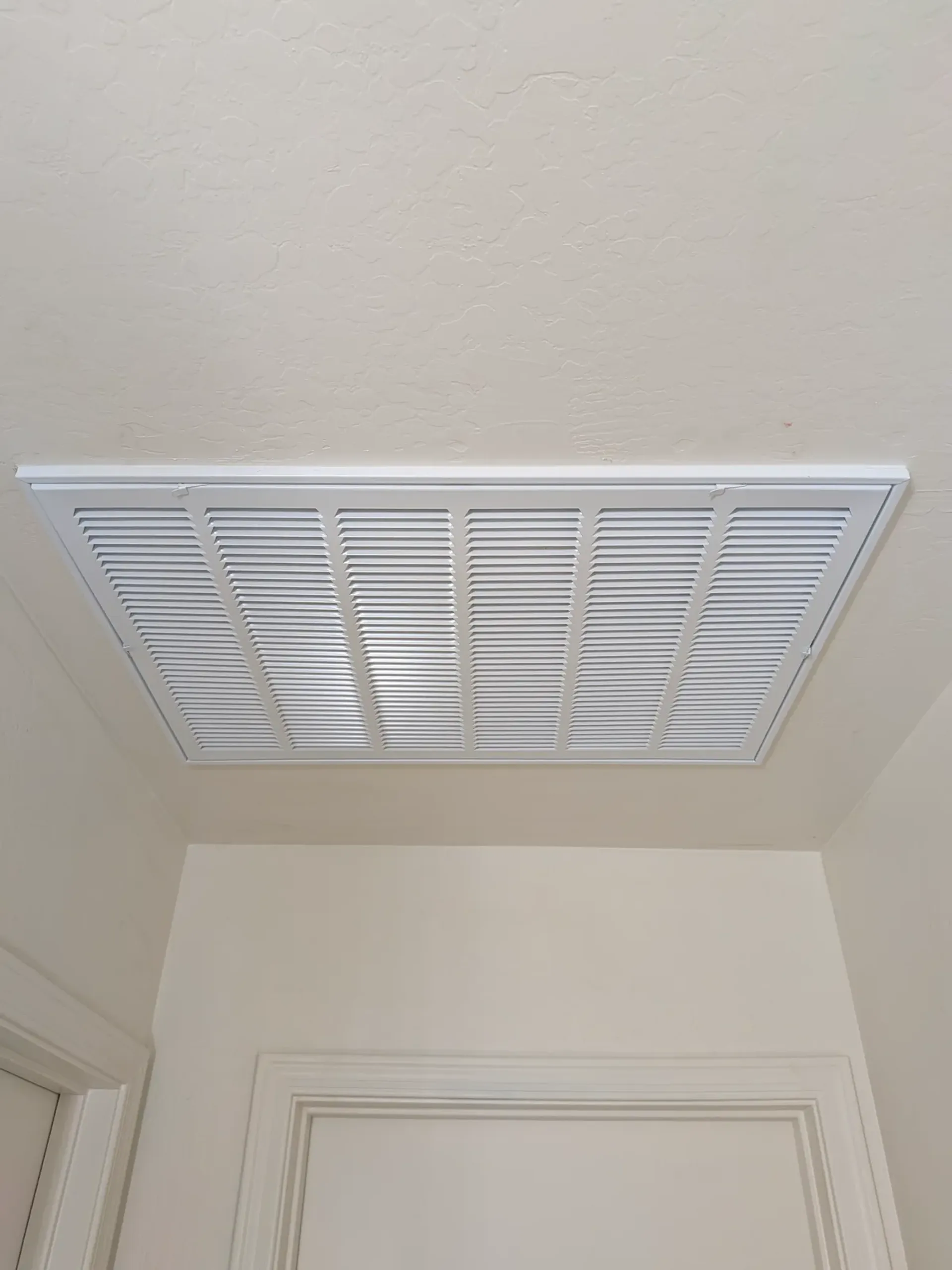 Clean white AC return grille installed in a Gilbert home