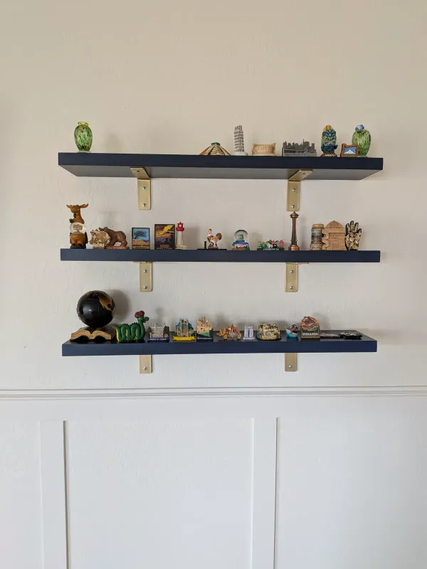 Painted floating shelves installed beside mounted TV in Gilbert
