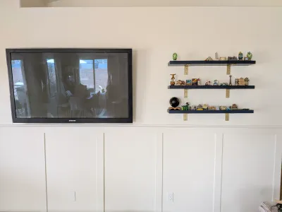 Mounted TV and floating shelves on a finished media wall in Gilbert