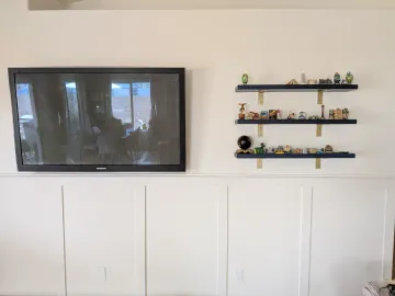 Mounted TV and floating shelves on a finished media wall in Gilbert